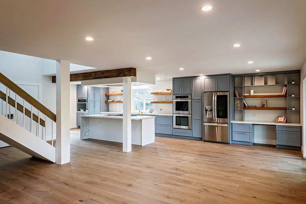 After LIS remodel — open-plan kitchen with blue-gray cabinetry, marble island, built-in shelving and wood floors