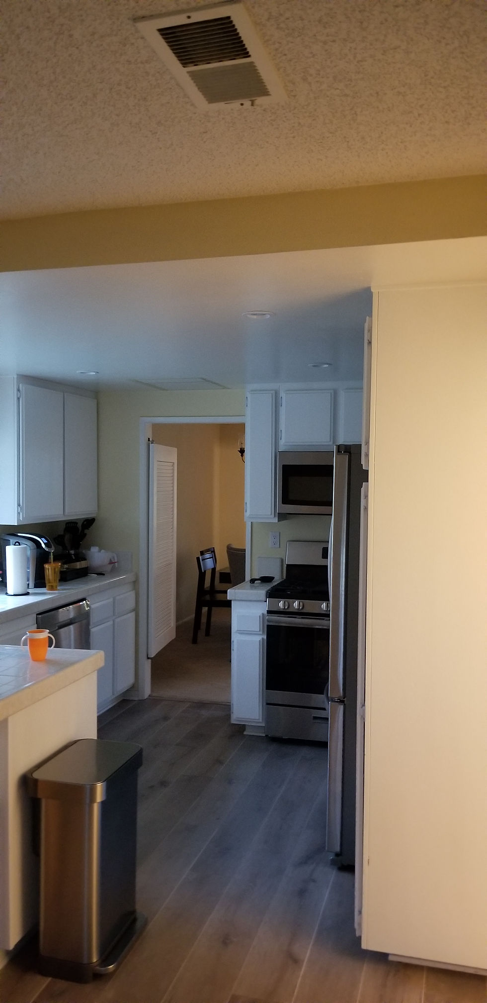 Hopkins kitchen before remodel — cramped white cabinets, tile counters and popcorn ceiling