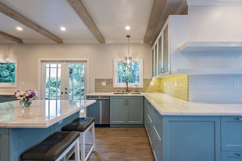 Citrus kitchen after LIS remodel — blue-green cabinetry, marble island and exposed beams