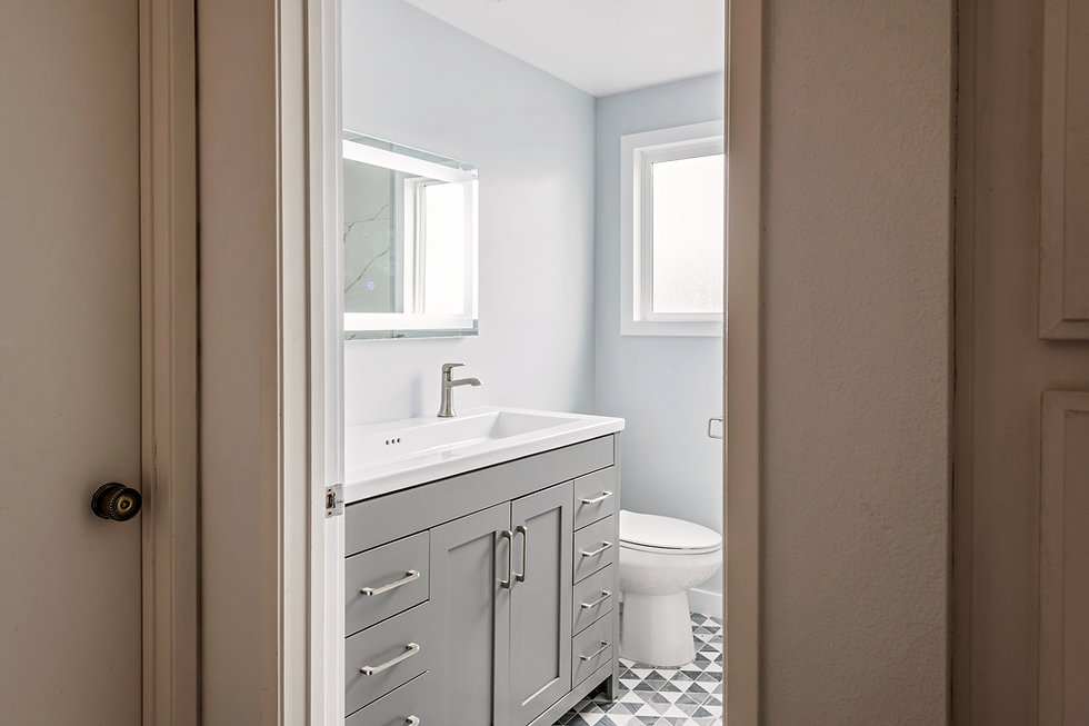 Hopkins bathroom after LIS remodel — gray vanity, backlit mirror and patterned tile floor