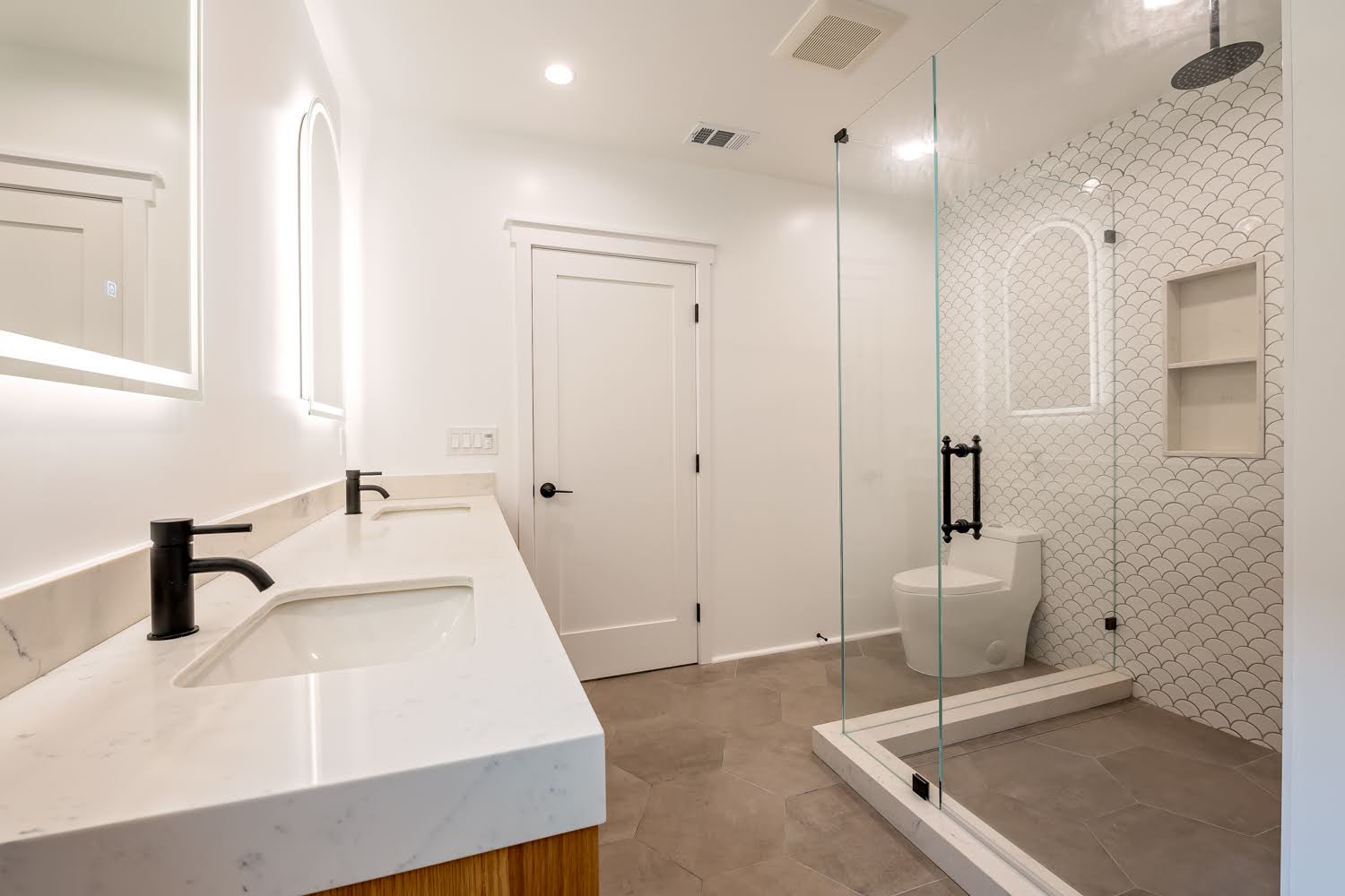 Lillian Master Bathroom — double vanity with marble counters, backlit mirrors and the glass shower enclosure