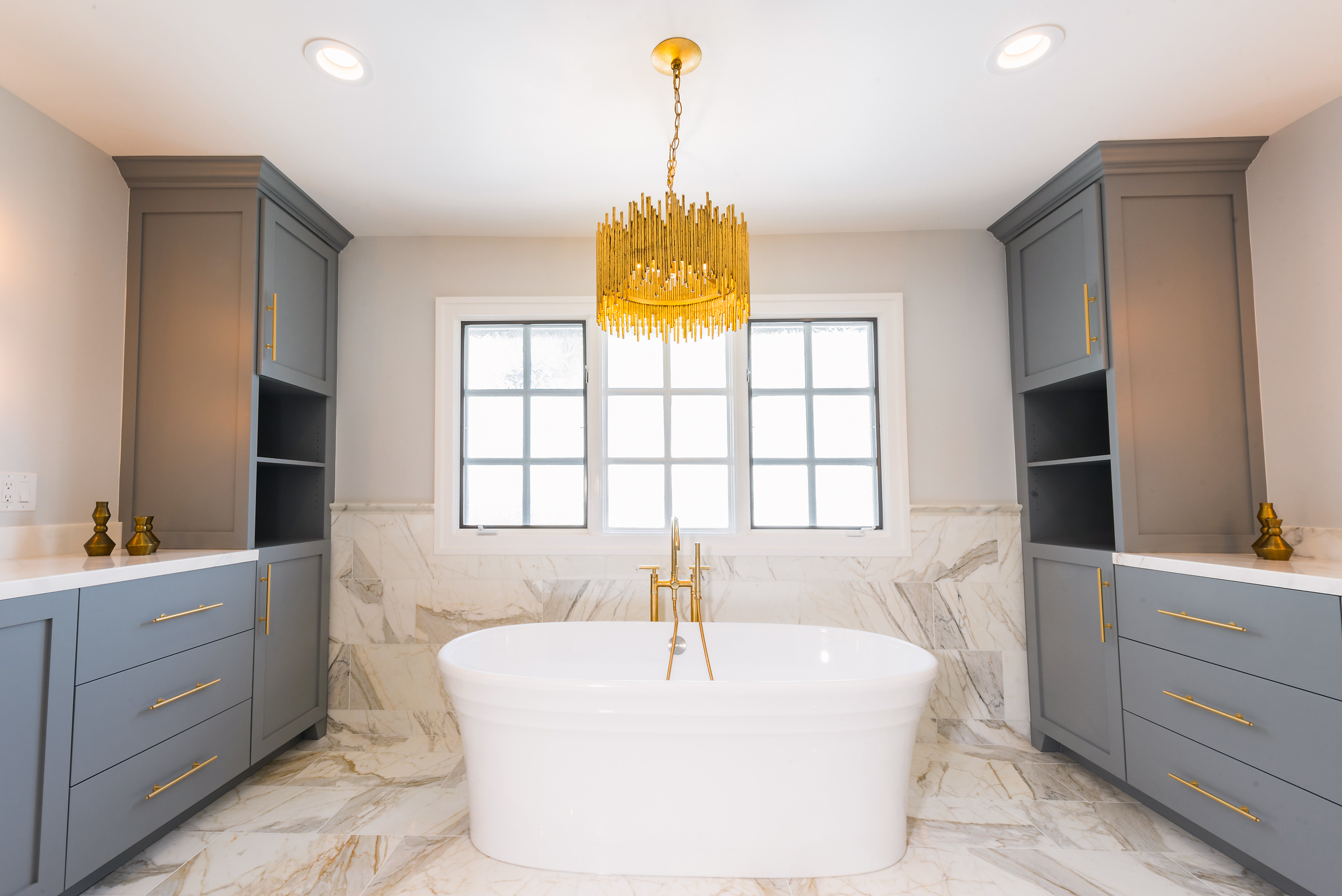 Elegant LIS bathroom remodel with freestanding tub, blue-gray cabinetry and marble finishes